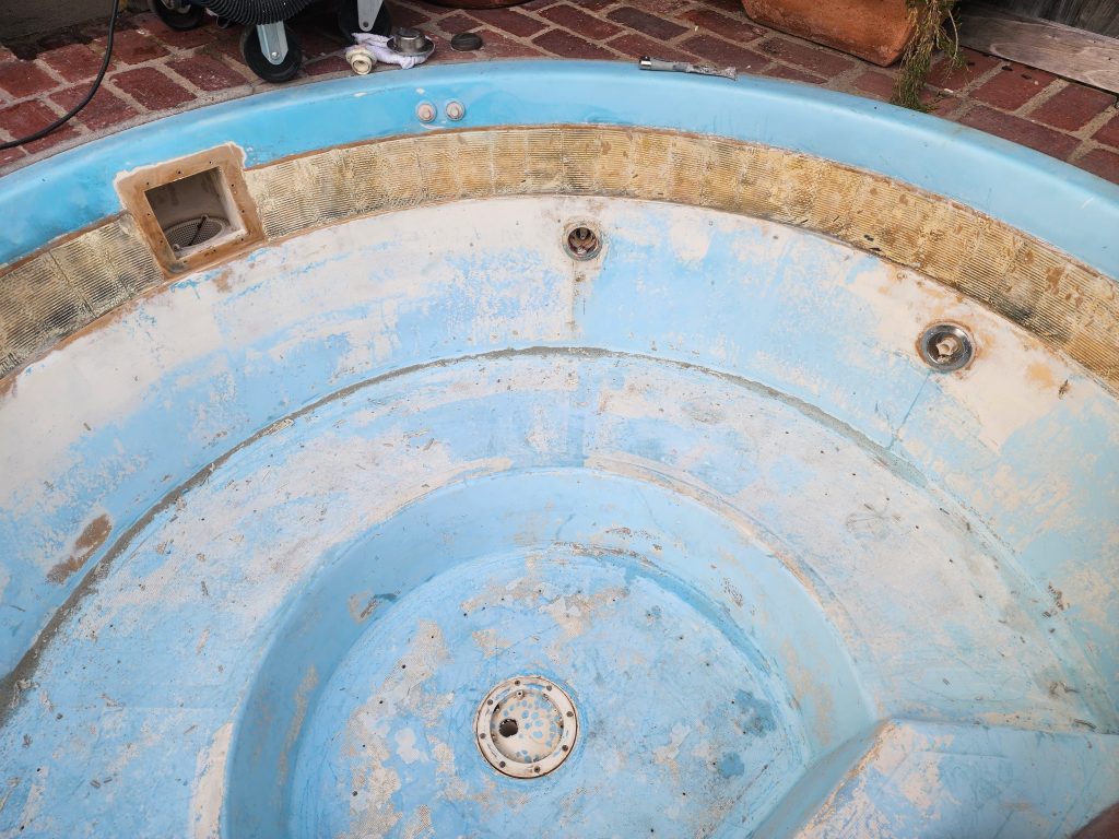 Drained spa with worn finish before resurfacing and repair by 1WaterGuys